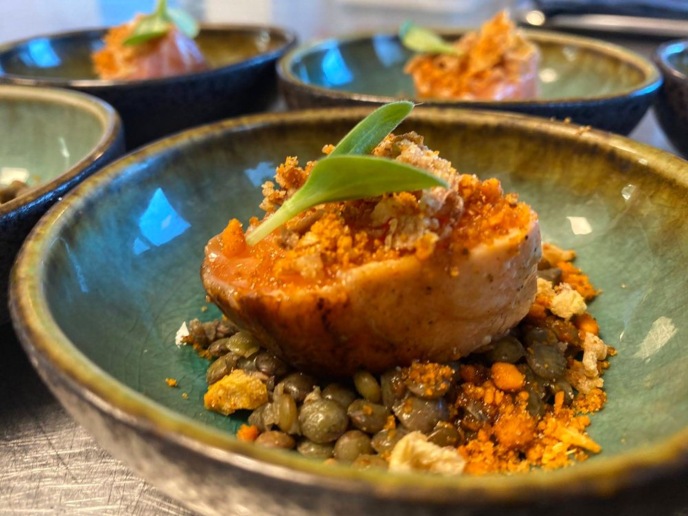 Plat dressé dans un bol turquoise, sur un lit de lentilles