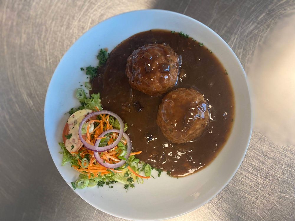 Boulettes nappées de sauce brune, avec leurs crudités