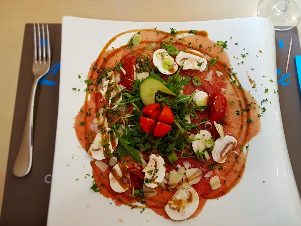 Carpaccio garni de champignons et de roquette